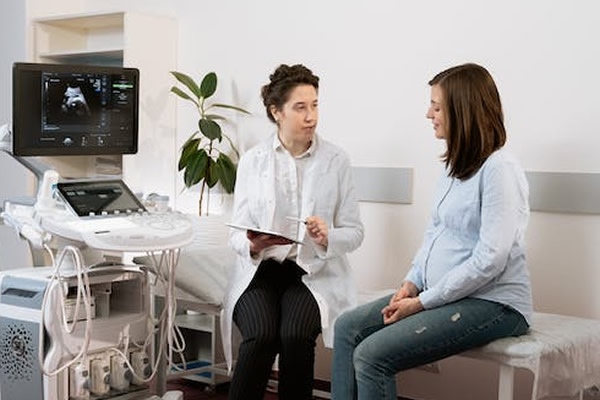 Doctora con paciente hablando en un consultorio médico. Data entry para Obras sociales y medicina